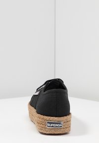 Baskets espadrilles en toile noire avec une semelle en jute tressé, dotées d'une étiquette avec logo et d'une couture simple. Vue arrière mettant en valeur la texture et le design.