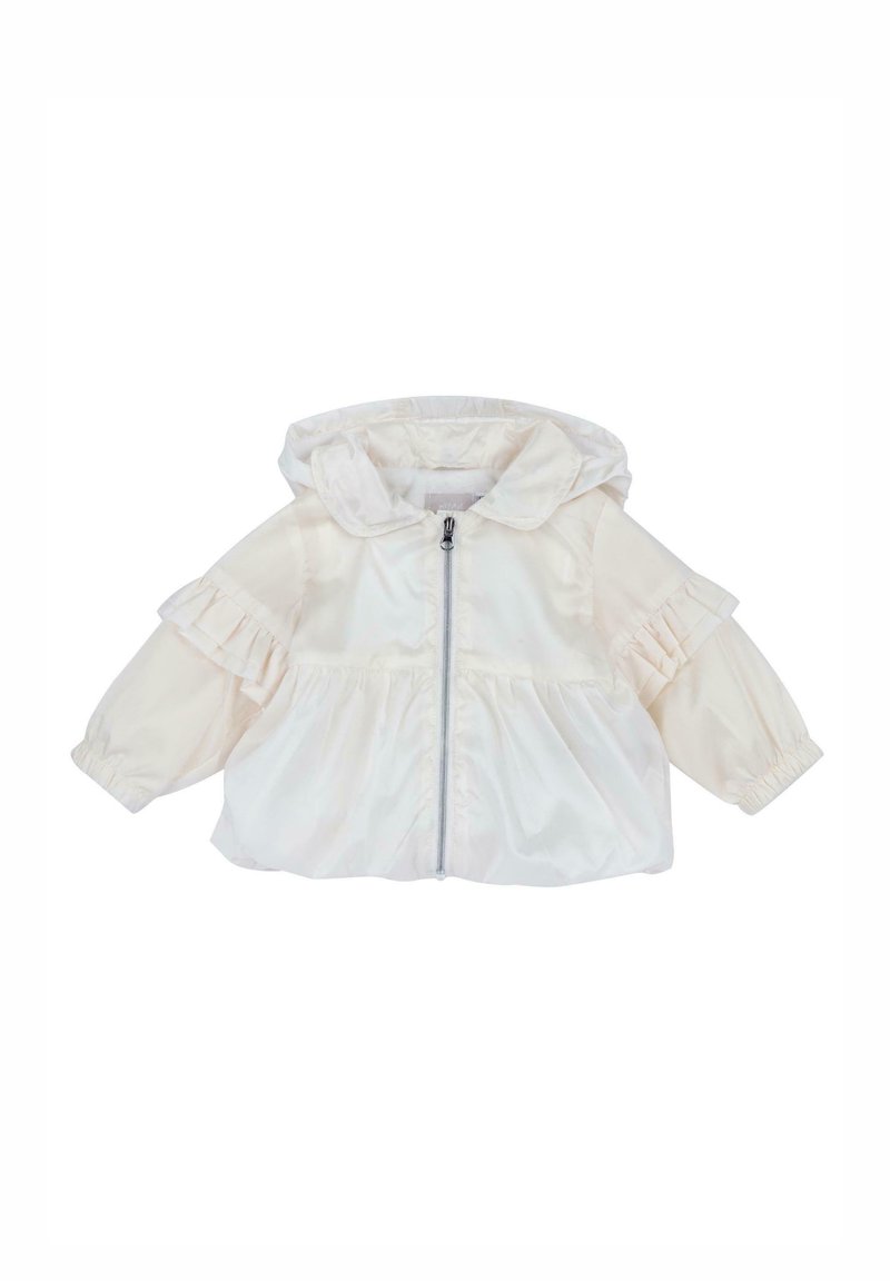 Veste coupe-vent crème clair avec capuche, détails plissés aux épaules, fermeture éclair frontale et poignets élastiques. Confectionnée en tissu lisse et léger.