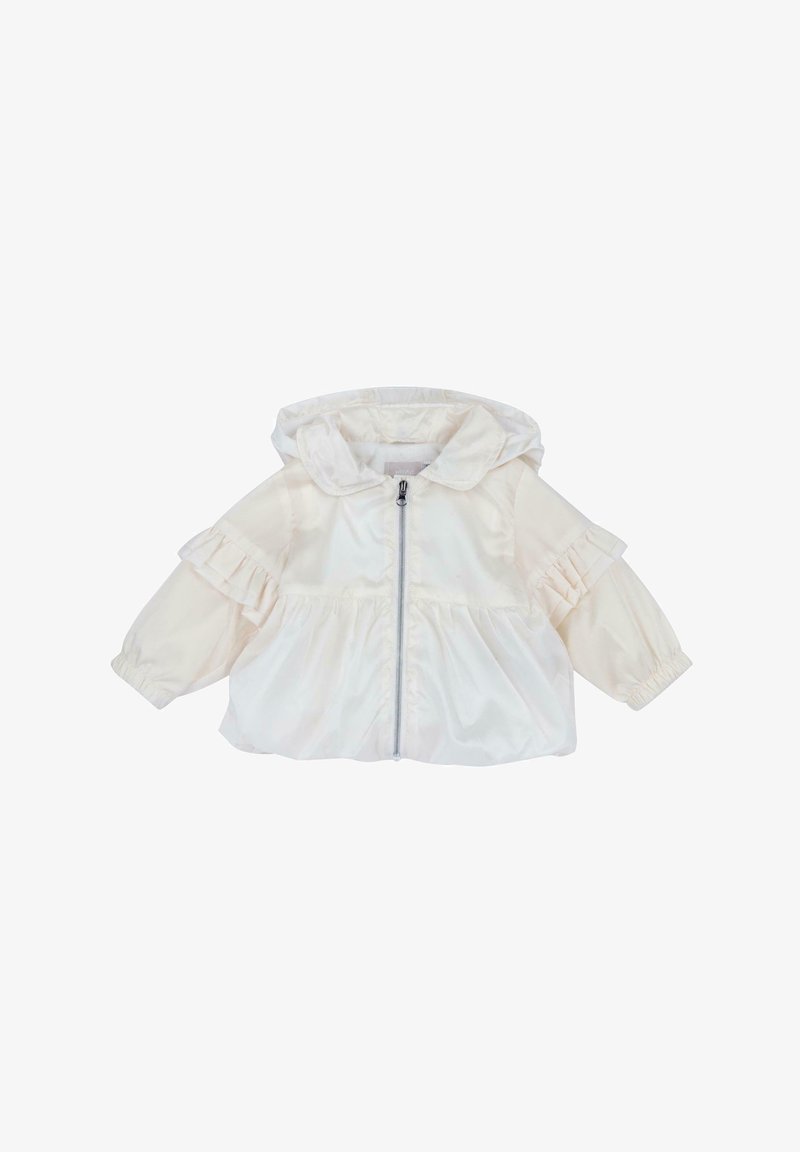 Veste coupe-vent crème clair avec capuche, détails plissés aux épaules, fermeture éclair frontale et poignets élastiques. Confectionnée en tissu lisse et léger.