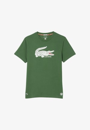 T-shirt verde a maniche corte con grande logo bianco a coccodrillo e testo "LACOSTE" al centro del petto, piccoli loghi vicino all'orlo.