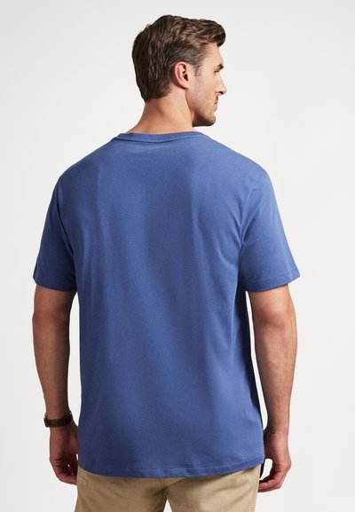 Īsās piedurknes, karaliski zilā kokvilnas T-krekls ar apaļu kakla izgriezumu un brīva piegriezuma siluetu, redzams no aizmugures, ar šuvju nesatricinātu plecu dizainu.