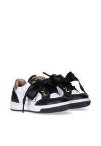 Le sneakers in pelle bianca e nera presentano hardware dorato, una suola in gomma testurizzata nera e ampie nastri in satin neri come lacci.
