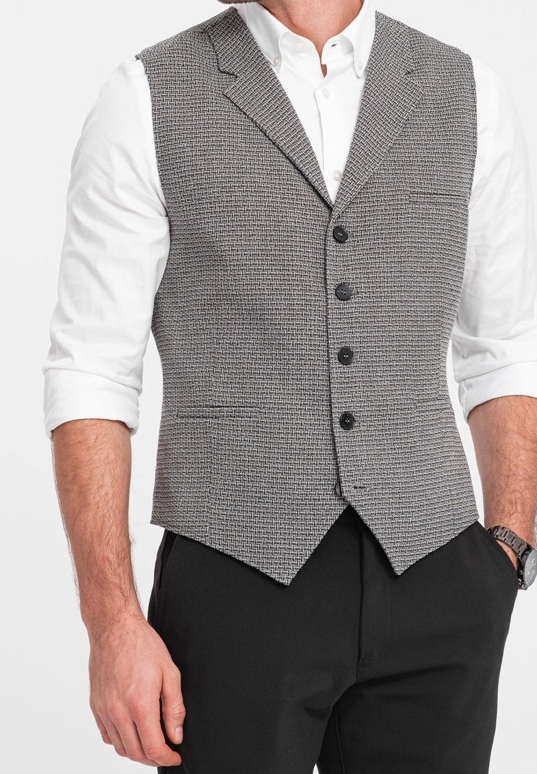 Grå houndstooth bomullsväst med kavajkrage, fem svarta knappar och spetsslut, bärs över en vit skjorta och svarta byxor.