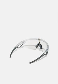 Transparente Schutzbrille mit grauen Akzenten, die ein leichtes Design, flexible Bügel und eine minimalistische, stromlinienförmige Form aufweist.