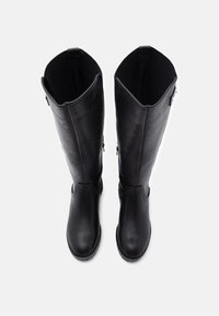 Bottes noires en cuir montant jusqu'au genou avec une texture lisse, des bouts arrondis et des fermetures éclair latérales pour un enfilage facile. Intérieur doté de panneaux en tissu élastique.