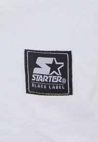 White fabric with a black square patch featuring the "STARTER" logo and "BLACK LABEL" text, outlined in white stitching.