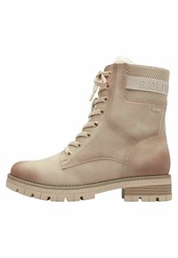 Bottines beiges en cuir lisse, avec un col rembourré, un laçage à l'avant et une semelle en caoutchouc texturé avec des profondeurs marquées.