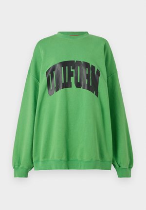 Green sweatshirt made of cotton, featuring a curved black "UNIFORM" print across the chest, with long sleeves and a relaxed fit.
