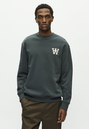 Dark gray sweatshirt with a crew neck, featuring a cream logo on the left chest. Soft fabric and ribbed cuffs and hem.