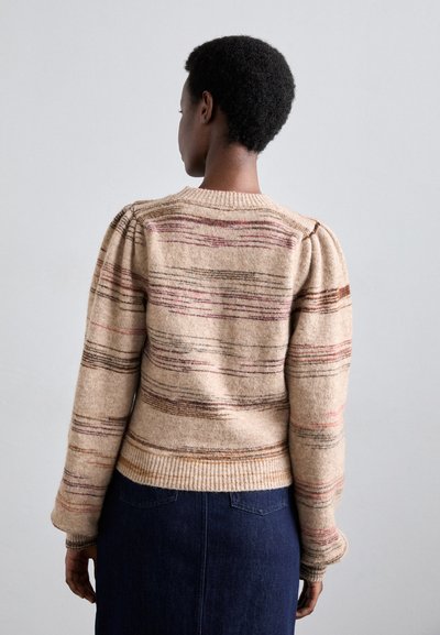 Beige ullgenser med horisontale striper i nyanser av brunt og rødt. Har en ribbestrikket kant og mansjetter, samt puffede ermer for et teksturert utseende.