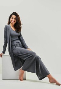 Grau gestrickter Lounge-Anzug mit langem Cardigan, kurzärmeligem Oberteil und weit geschnittenen Hosen in bequemer, lässiger Passform. Glatte Textur.