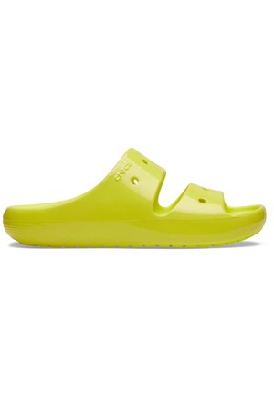 Jasnożółta sandałka wsuwana z dwoma paskami i otworami wentylacyjnymi, płaska podeszwa i wytłoczona marka "Crocs" na boku.