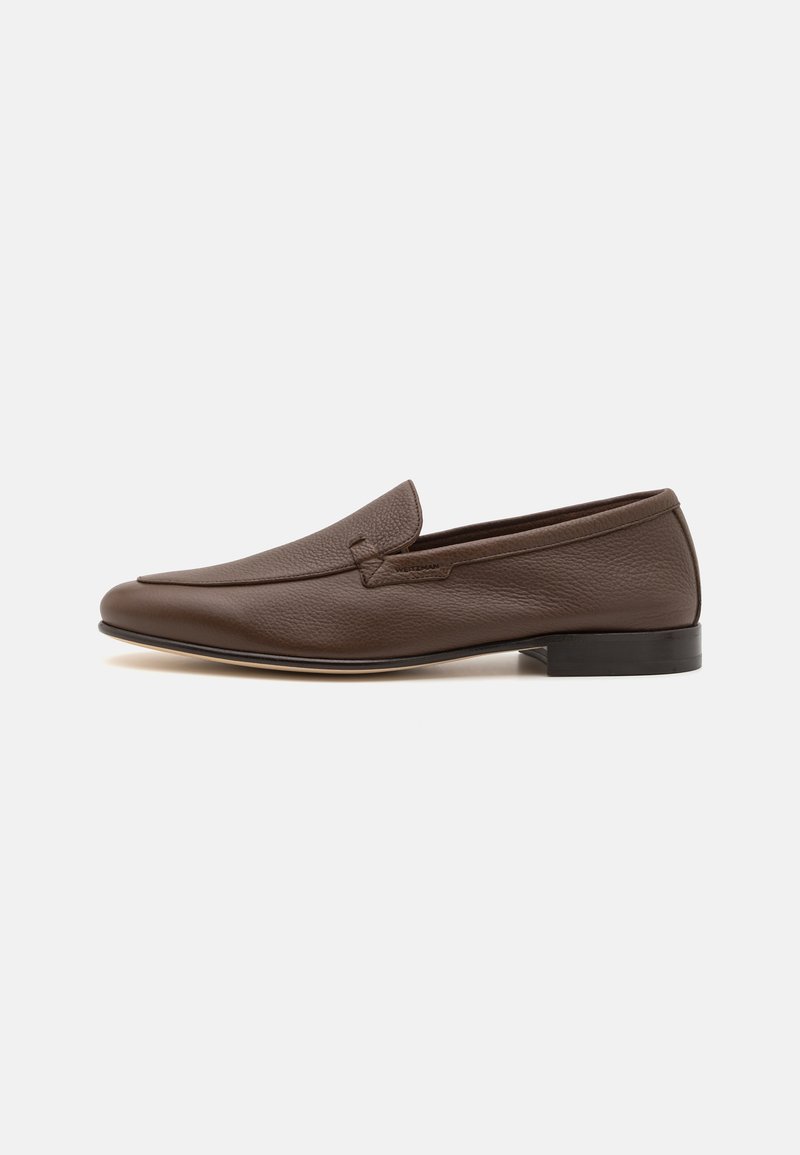 Mocassins en cuir marron avec un bout arrondi, une surface texturée et un talon plat. Design simple avec un détail de couture discret sur le dessus.