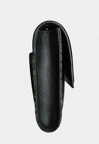 Billetera de cuero negro con textura suave, parte superior curva y costuras bien hechas a lo largo de los bordes. Forma compacta diseñada para la portabilidad.