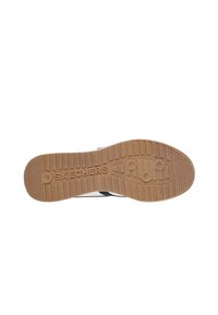 Suela de zapato Skechers con una base de goma marrón texturizada, que presenta un patrón de zigzag y un logotipo en relieve para proporcionar tracción y soporte.