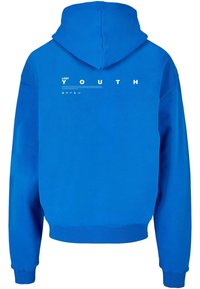 Modrá mikina s kapucí obsahující přední klokanku, stahovací šňůrku na kapuci a bílý potisk s textem "ZTRACENÁ MLÁDEŽ" na zadní straně. Text obsahuje symboly.