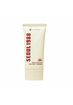 Sonnencreme-Tube mit der Aufschrift "SEOUL 1988" mit SPF 50+, enthält Kiefer und Ceramid, von der Marke K-Secret, beige und rote Verpackung.