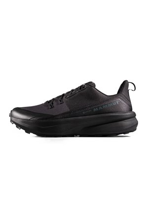 Chaussure de randonnée basse noire avec semelle épaisse, lacets à l'avant, languette au talon et marquage "Mammut" sur le côté.
