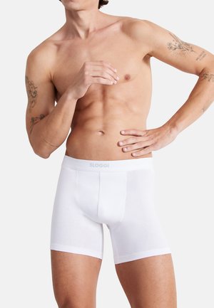 Weiße Boxershorts aus weichem Stoff mit einem elastischen Logo-Bund. Das Design ist enganliegend mit einer Länge bis zur Mitte des Oberschenkels und ohne sichtbare Muster.