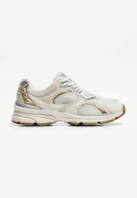 Chaussure de sport en mesh beige clair et blanc avec des accents dorés et argentés, semelle épaisse, et fermeture à lacets vue de profil.