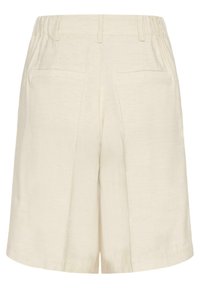 Shorts taille haute écru avec ceinture élastique sur les côtés, passants pour ceinture, et deux poches passepoilées à l'arrière.