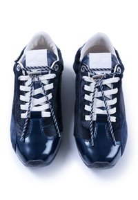 Zapatillas de navy que presentan una mezcla de cuero suave y piel de pelo, cordones blancos y un acento brillante en la punta. Paneles laterales texturizados.
