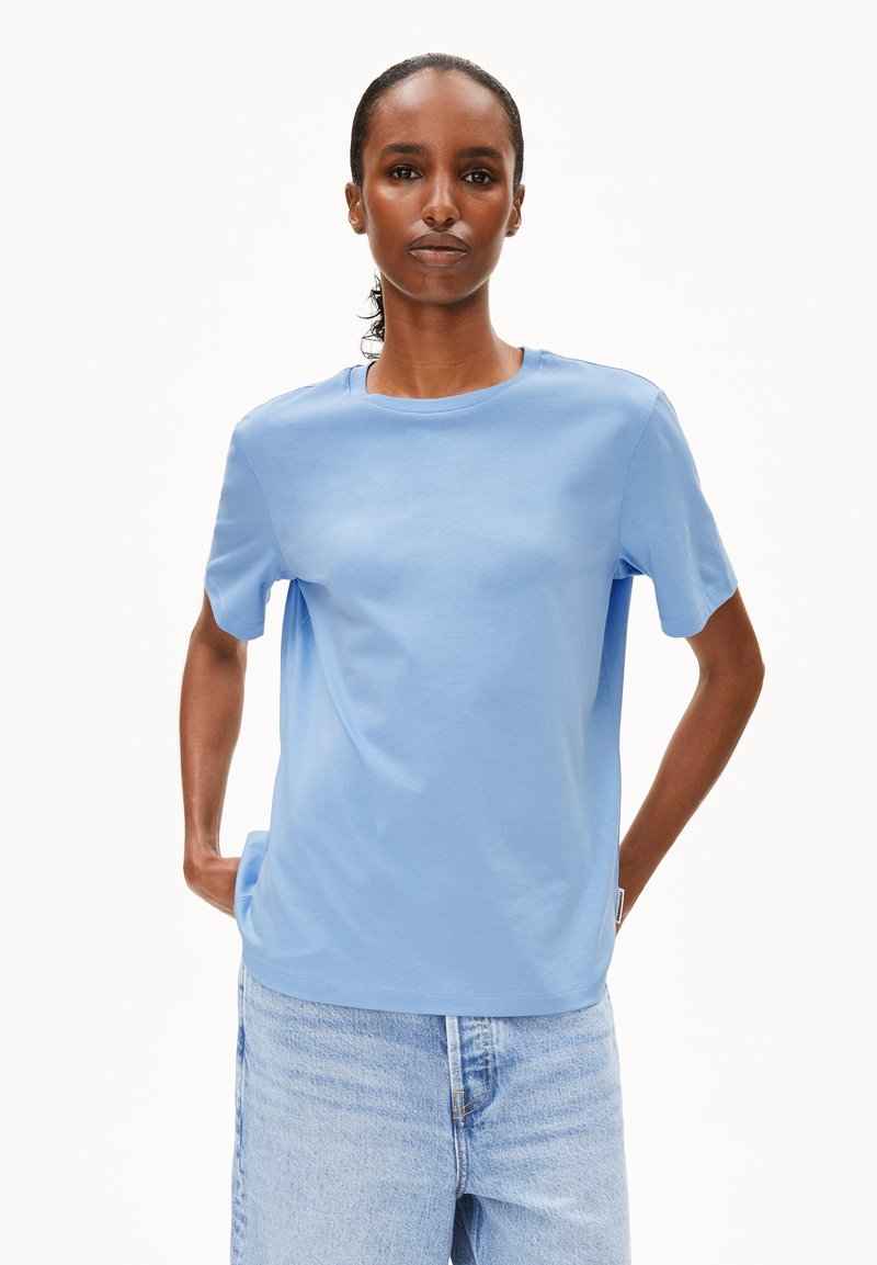 T-shirt bleu clair à manches courtes en coton doux, avec un col rond et une coupe décontractée, associé à un short en denim.