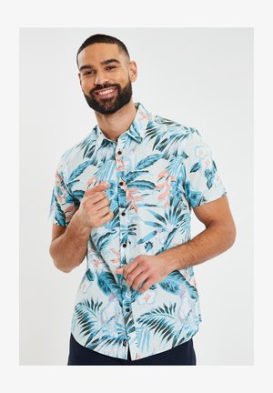 Camisa de botones de manga corta en azul claro con un estampado floral tropical en rosa, blanco y verde, con una textura suave y cuello.
