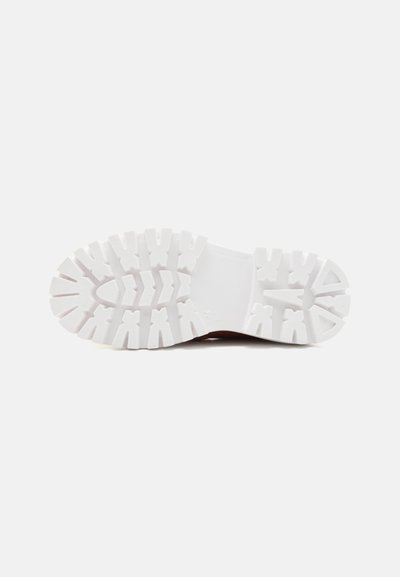Gummisåle med en strukturert hvit finish, dype riller og et symmetrisk mønster for bedre grep. Glatt hældesign.