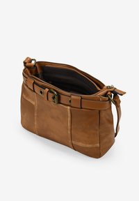 Bolso de hombro de cuero marrón con correa ajustable, detalles de hebilla de latón y un compartimento principal con cremallera abierta que muestra un forro interior oscuro.