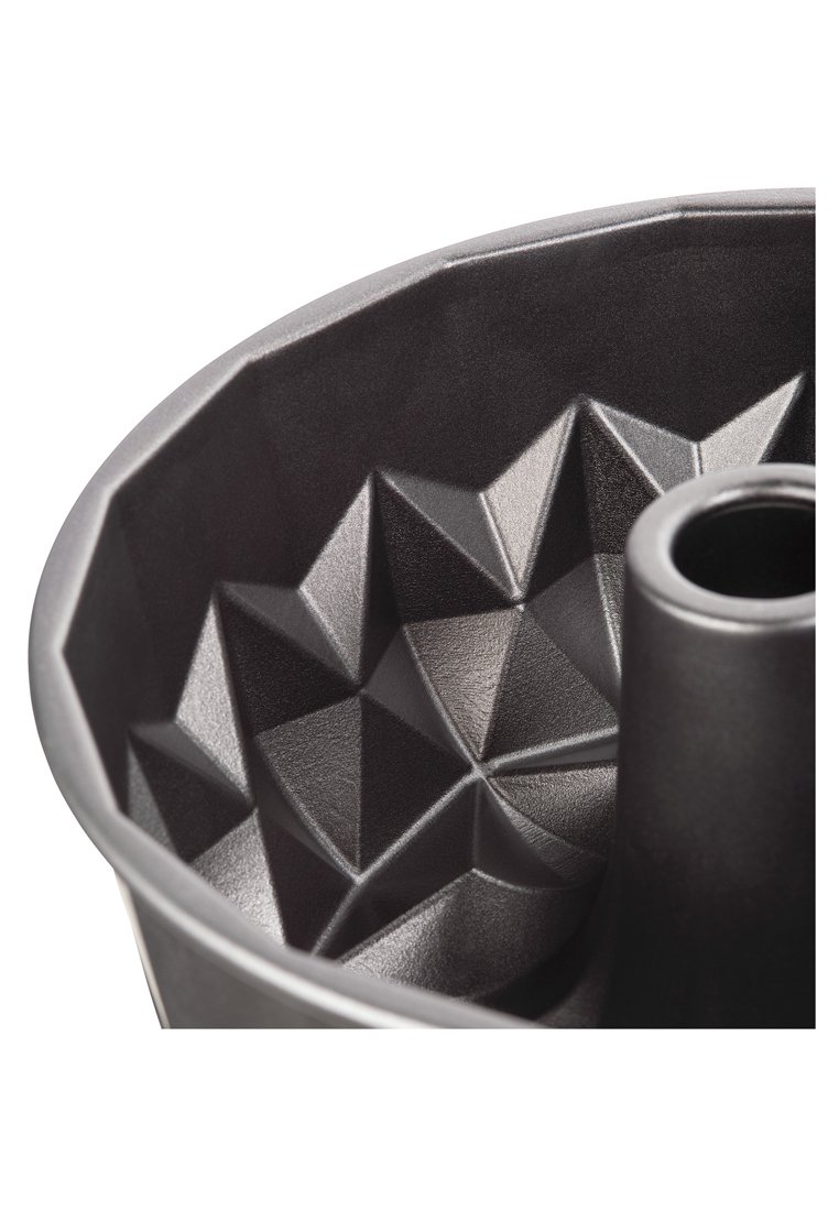 Schwarz metallene Backform mit strukturiertem, geometrischem Muster, das erhabene sternförmige Formen und ein zentrales Rohr für gleichmäßiges Backen aufweist.