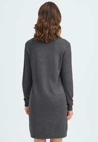 Tummaharmaa neulemekko, jossa on pitkät hihat, ribbatut hihansuut ja rento malli. Valmistettu pehmeästä, teksturoidusta neulekankaasta, polvenpituinen malli.