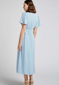 Robe midi bleue à motifs floraux avec des manches courtes évasées, taille froncée et tissu léger. Texture lisse avec un motif délicat en blanc.