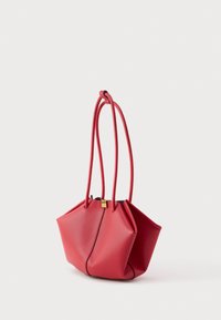 Borsa a tracolla in pelle rossa con forma geometrica unica e due manici lunghi e sottili su sfondo bianco.