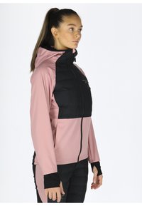 Zwarte en roze sportjacket met een ritssluiting aan de voorkant, capuchon en textuurpanelen. Lange mouwen met duimgaten, ontworpen voor comfort en bewegingsvrijheid.