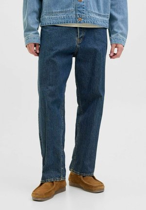 Jeans i denim i mörkblått med avslappnad passform, med rak benkjol, subtil blekning och ljusa sömmar. Matchas med bruna mockaskor.