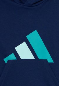 Marinblå hoodie med en framficka som har tre lutande ljusblå ränder. Tillverkad av mjukt tyg, med ribbade ärmslut och huva med dragsko.