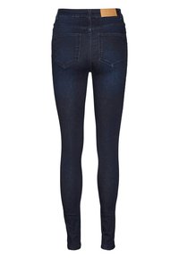 Jeans ajustados de mezclilla azul oscuro con una textura suave. Cuenta con dos bolsillos traseros y una etiqueta de color marrón en la cintura.