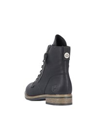 Bottine noire en cuir avec une fermeture éclair sur le côté, un lacet et un talon en bois texturé de couleur marron clair. Points forts : un accent en métal à l'arrière.