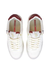 Vita lädersneakers med burgundifärgade detaljer, perforerat tån, platta snören och en gyllene emblem på tungan. Insidan har varumärkesmärkning.