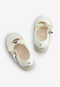 Scarpe Mary Jane bianche glitterate con punta arrotondata, tomaia texturizzata, un fiocco decorativo e una suola piatta traslucida.
