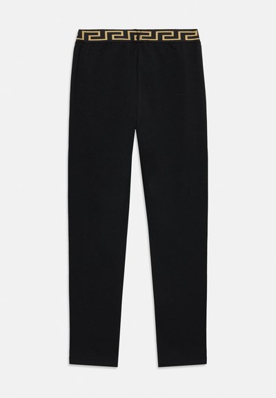 Juodos tamprės iš minkštos medžiagos, su auksiniu raštuotu elastiniu liemeniu. Tiesaus kirpimo kojos, be ryškių siūlių ar detalių.