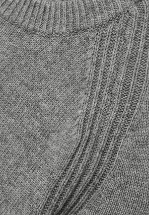 Grå strikket sweaterdetalje med en ribbet halsudskæring og teksturerede mønstre. Stoffet ser blødt ud med forskellige syningsteknikker.