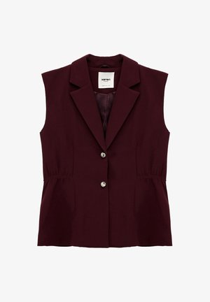 Hihaton burgundinpuna sävyinen liivi käännettävällä kauluksella, kahdella edessä olevalla napilla ja hienovaraisesti kerätyillä sivusaumoilla, kauluksen sisäpuolella lukee "Koton Business".