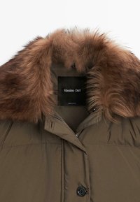 Giacca imbottita marrone con ampio colletto in pelliccia morbida, bottone nero e etichetta Massimo Dutti visibile all'interno del collo.