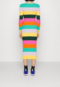 Vestido ajustado de canalé de manga larga con rayas multicolores en rosa, verde, amarillo y naranja. Hasta la rodilla con un sutil detalle en el dobladillo.