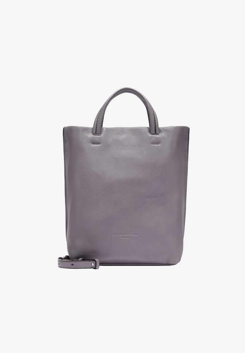 Leather tote bag in soft lavender with two top handles. Features a minimalist design, smooth texture, and embossed logo at the base.