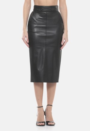 Gonna a matita nera in finta pelle a vita alta con cintura, indossata con sandali neri con cinturino alla caviglia e punta aperta, modello in piedi su sfondo bianco.