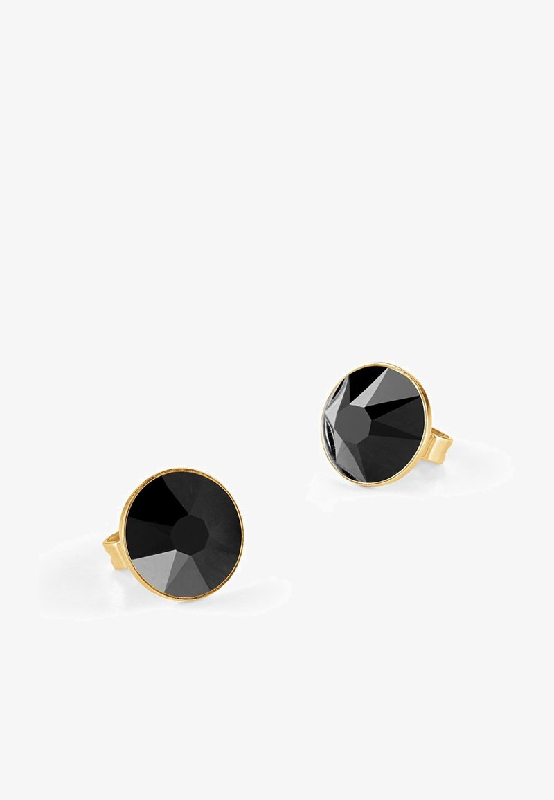 Boucles d'oreilles cloutées noires en métal doré, présentant des formes rondes aux bords lisses. Les surfaces réfléchissantes accentuent le design.