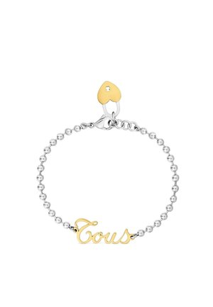 Bracciale con catena di perline d'argento con scritta "Tous" in oro e un piccolo ciondolo a forma di cuore in oro vicino alla chiusura.